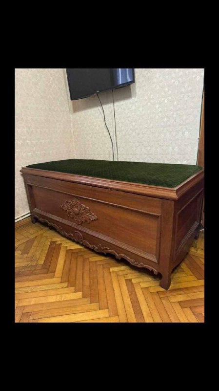 Деревянная кровать с резьбой и зеленой обивкой
