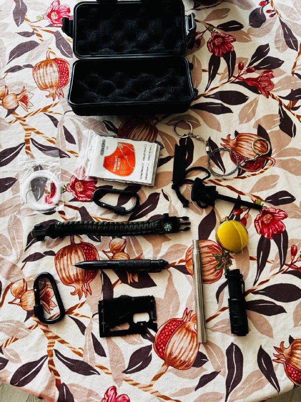 Various outdoor survival and camping tools with case