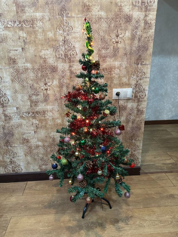 Two artificial Christmas trees with decorations and garlands