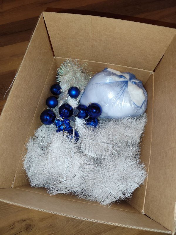 Небольшая белая искусственная елка с украшениями и ватой