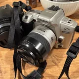 Polaroid camera, Panasonic camera, tanning foam, eyeliner, adapter, Minolta camera, headphones, tennis balls, women's bag 7