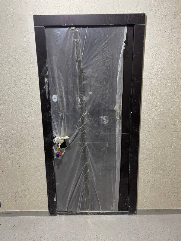 Входная дверь с каркасом и ключами после ремонта