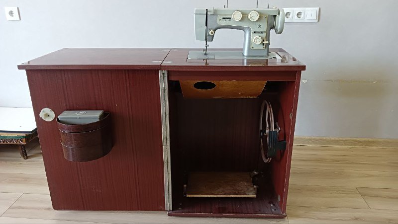 Швейная машина в шкафу с аксессуарами