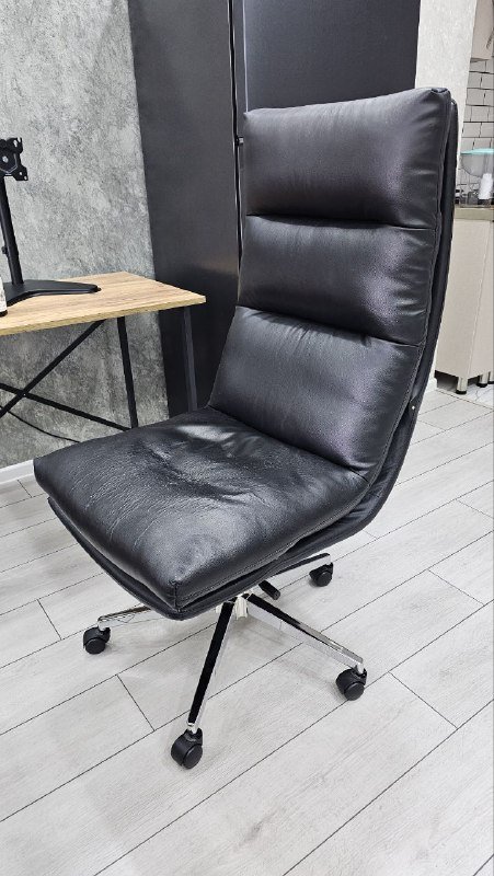 Черное кресло с поврежденным сиденьем