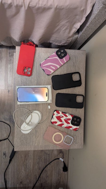 iPhone 16 Pro с чехлами и зарядным устройством