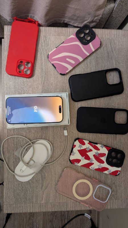 iPhone 16 Pro с чехлами и зарядным устройством