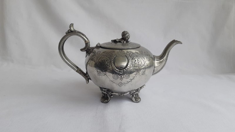 Старинный серебристый чайник с узорами